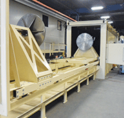 Figure 2: Round plates mounted on a sliding loading cart secure and rotate 6,000-pound cylindrical parts during processing