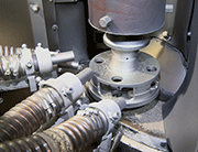 Blasting station with four pressure-blast nozzles directed at a gear component
