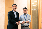 Prof. Tan Sze Wee from A*STAR giving the token of appreciation to Takashi Sato, one of the technical committee members as well as keynote speakers