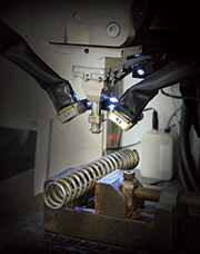 Figure 1a, 1b. A coil spring undergoing XRD residual stress testing on a Proto LXRD