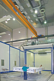 Open-space paint spraying system with long-range nozzles and telescopic cabin in parking position