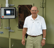 Herb Tobben, Sample Processing Manager, in the lab standing alongside his new state-of-the-art multi-functional automated blast-process simulator.