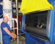 Tjakko Brouwer at the drum blast cleaning machine with a rubber belt
